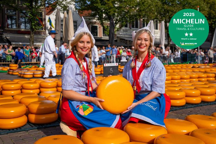 Cheese girls hold a large round cheese at the Cheese Market in Alkmaar.